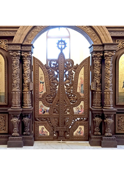 Carved iconostasis made of alder without gilding, featuring ornate Royal Gates in the shape of a trident.